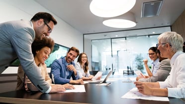 Eine Personengruppe sitzt an einem Tisch und führt einen Workshop durch