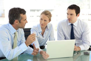 Three business people in a discussion with laptop at the table