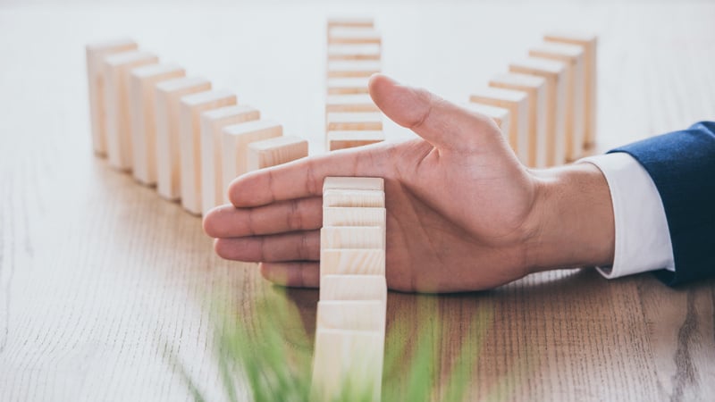 Hand prevents a domino chain from falling